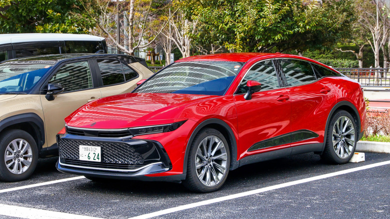 A red crossover car Toyota Crown parked.
