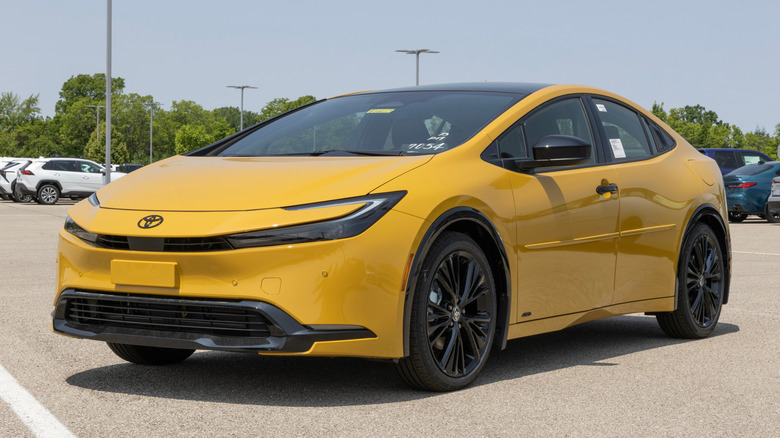 A yellow Toyota Prius parked in a parking lot.