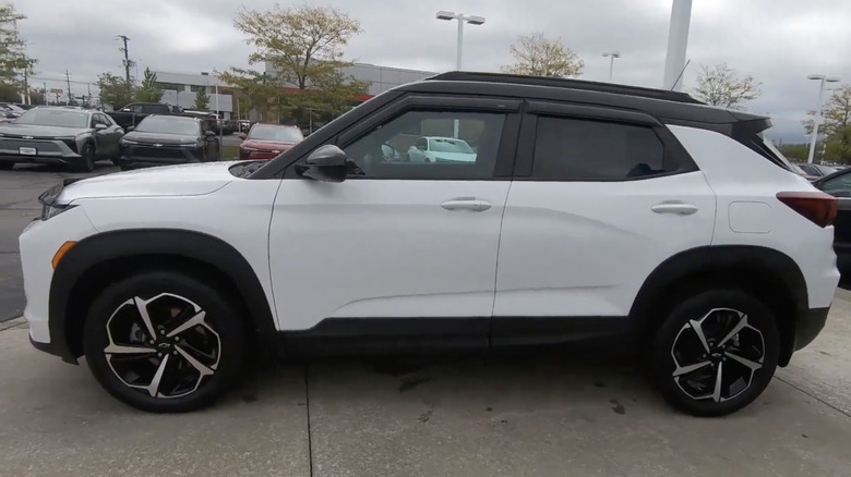 A black and white 2022 Chevrolet Trailblazer RS outside of a dealership on a cloudy day
