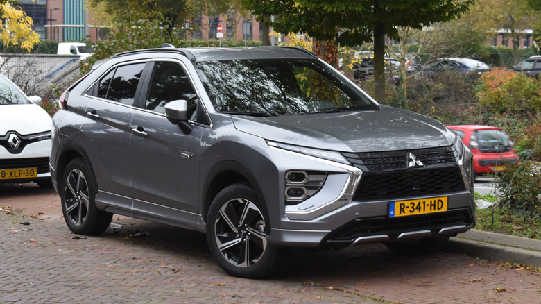 A dark gray 2022 Mitsubishi Eclipse Cross parallel parked on a brick road
