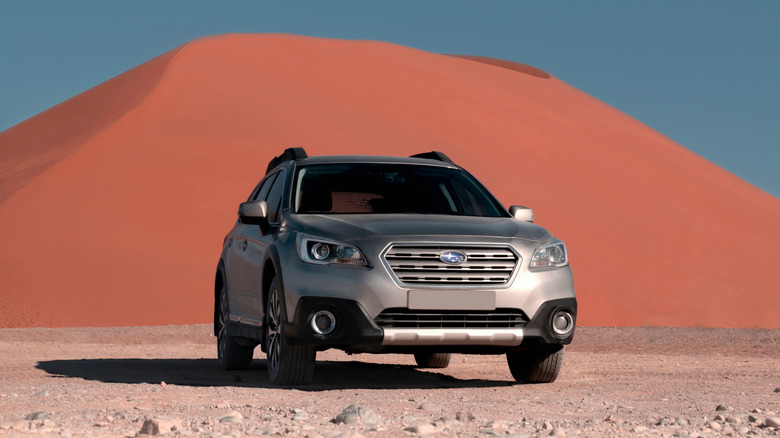 A Subaru Outback parked in the desert.
