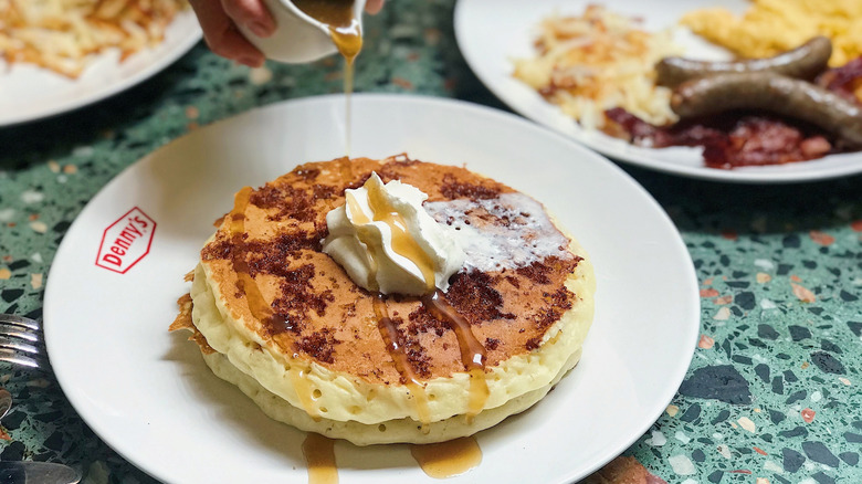 Fluffy Denny's pancakes drizzled with rich maple syrup, capturing the perfect balance of sweetness and warmth for a classic breakfast delight.