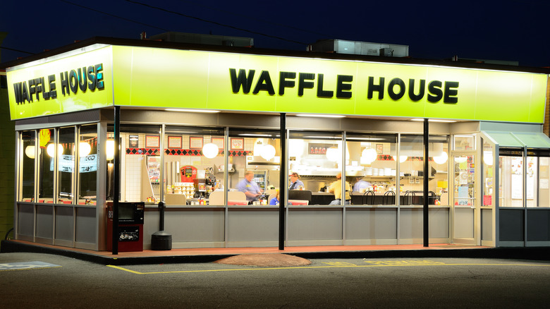 An outside view of a Waffle House location lit up at night.