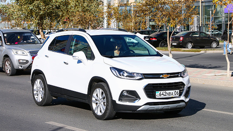 White crossover car Chevrolet Trax in the city street.