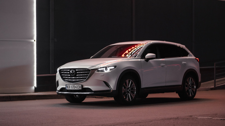 White Mazda CX-9 near warehouse at night