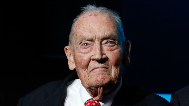 John Bogle in his later years wearing dark suit with red tie