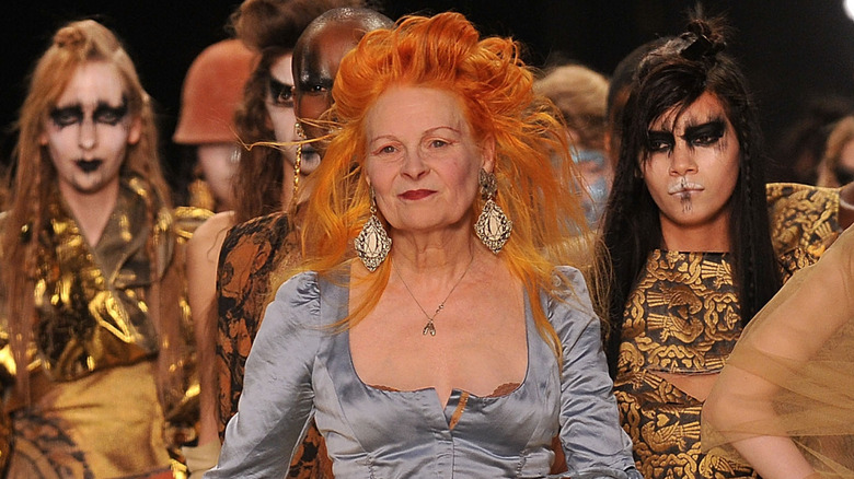 Designer Vivienne Westwood and models walking a fashion runway.