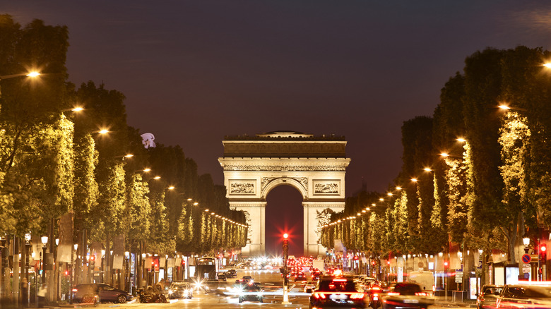 France, Paris, busy Champs Elysee and Arc de Triomphe with cars at night