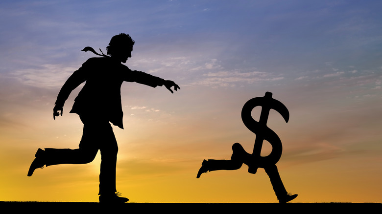 person chasing money sign