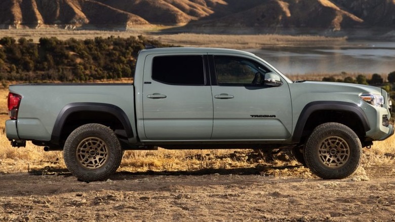A grey Toyota Tacoma truck parked near a lake