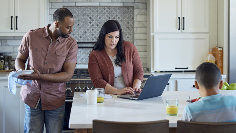 young family budgeting on a laptop in their kitchen
