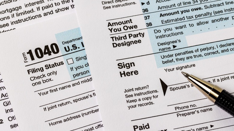 A pen sitting on top of American tax forms that still need to be filled out.