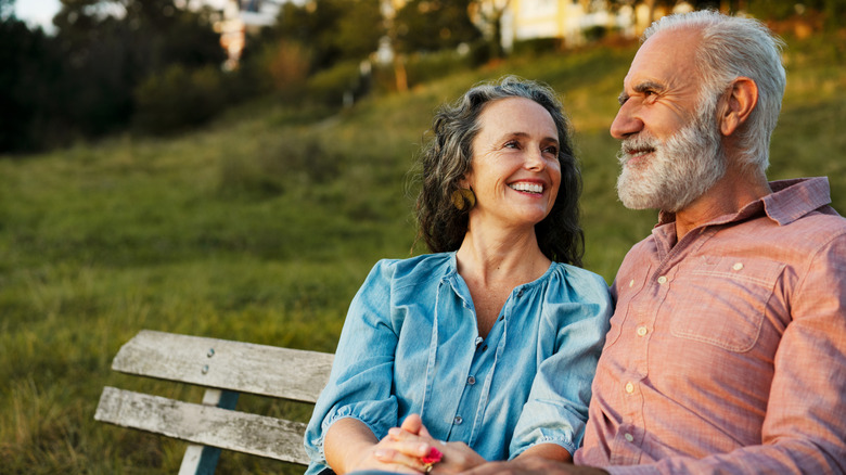 a retired couple sitting on a bench
