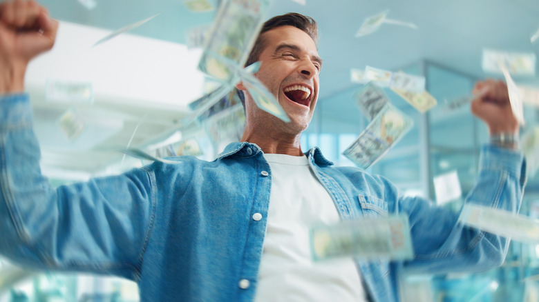 Man with money flying around him