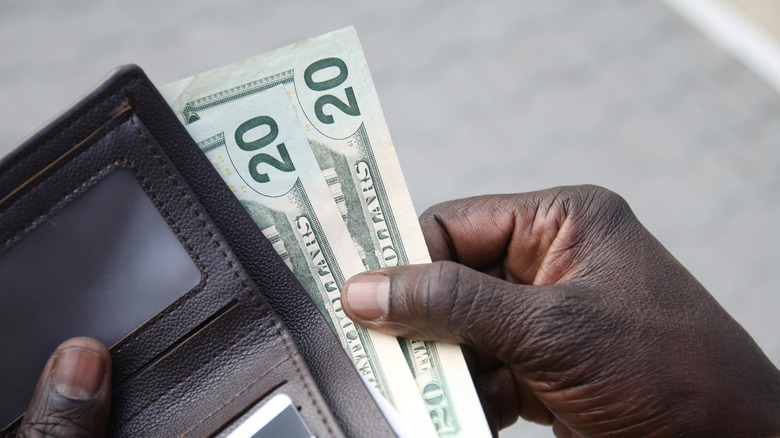 Man pulling cash out of his wallet