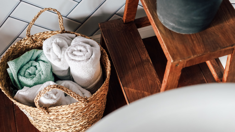 Towels rolled in a woven basket in a spa-like bathroom