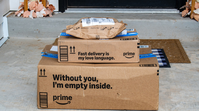 A stack of Amazon Prime delivery packages on a festive fall front stoop