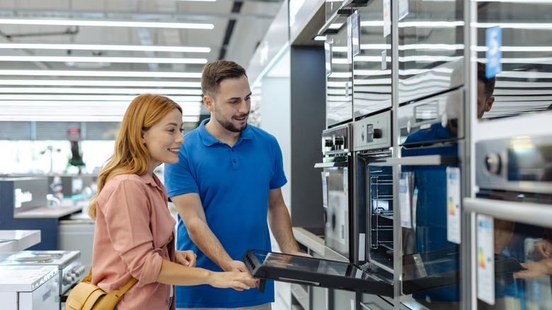 Salesperson showing a woman home appliances