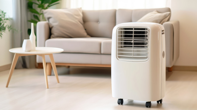 photo of white portable ac unit in a room with grey couch in the background
