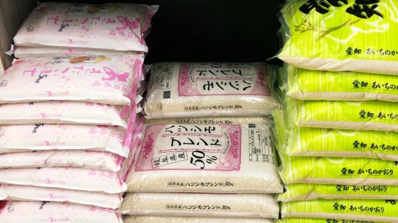 Stacks of imported rice in bags at a grocery store.