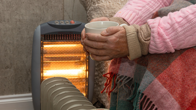 Person warming their hands near a space heater
