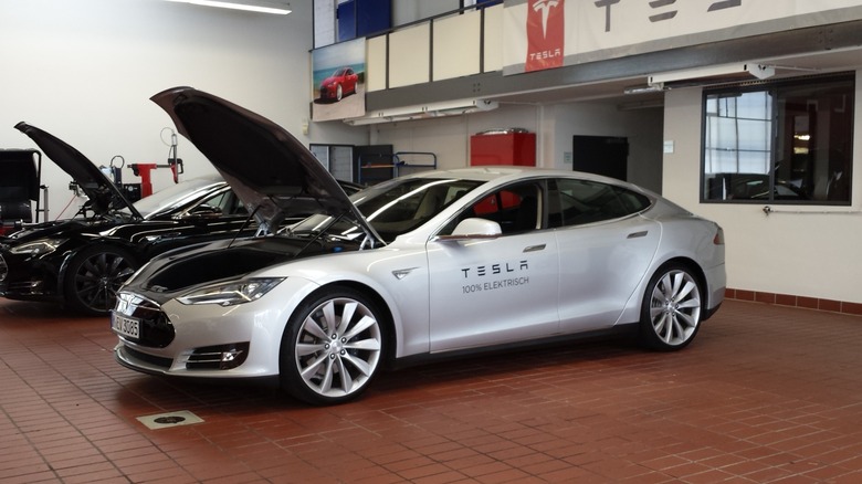 Tesla Model S with its hood open inside an auto service garage