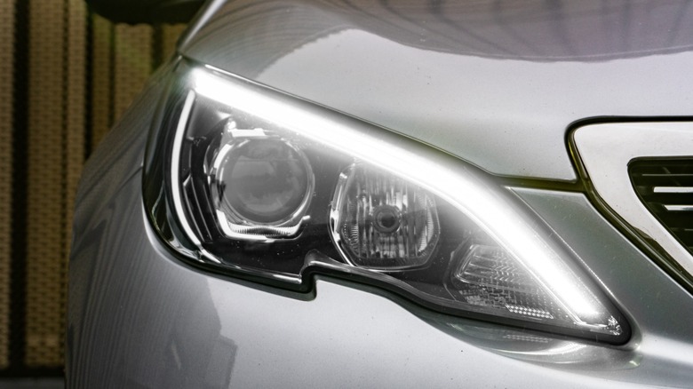 Close-up of a modern car headlight with illuminated LED daytime running light