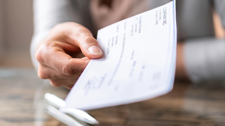 person handing over a paycheck