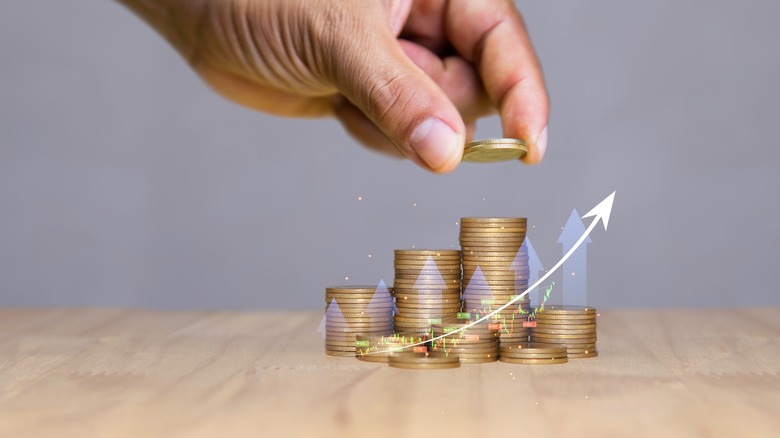 stacking coins with market chart overlaid on stacks