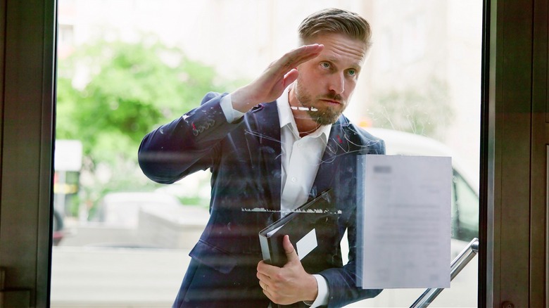 Person peering through window