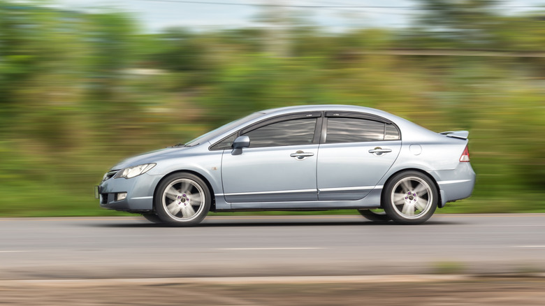 A gray 2025 Honda Civic cruising on a rural back road.
