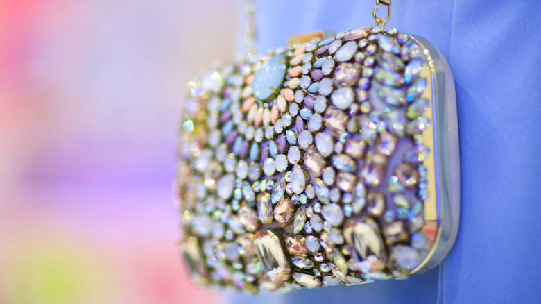 Woman cleans and examines a leather handbag