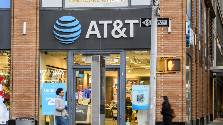 Pedestrians passing by the front of an AT&T store