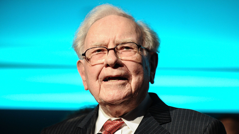 Warren Buffett in front of a blue screen.