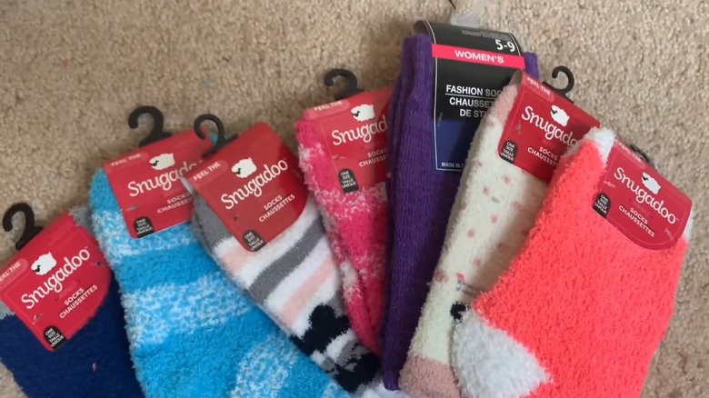 Several pairs of Snugadoo socks spread on a carpet floor