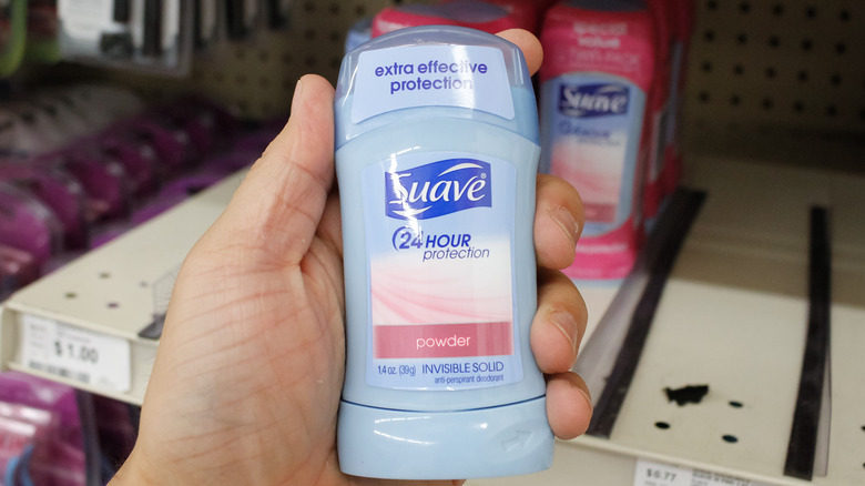 Hand holding Suave deodorant product t in store aisle
