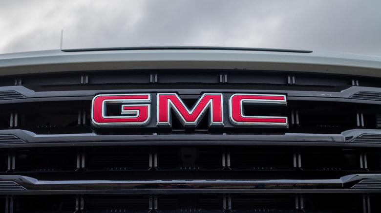 A closeup of a silver GMC vehicle's grill