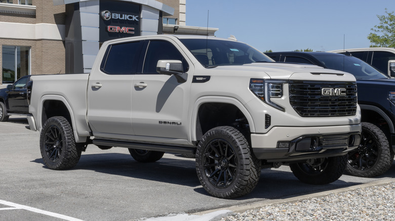 An off-white GMC Sierra 1500 Denali 4WD truck at a dealership.