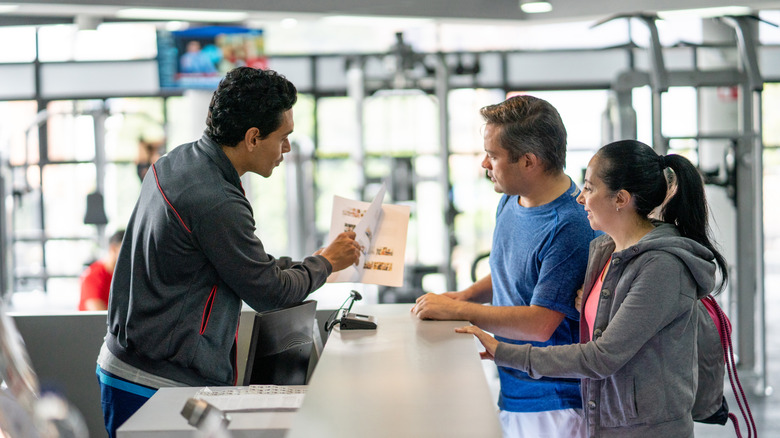 A couple signing a gym membership