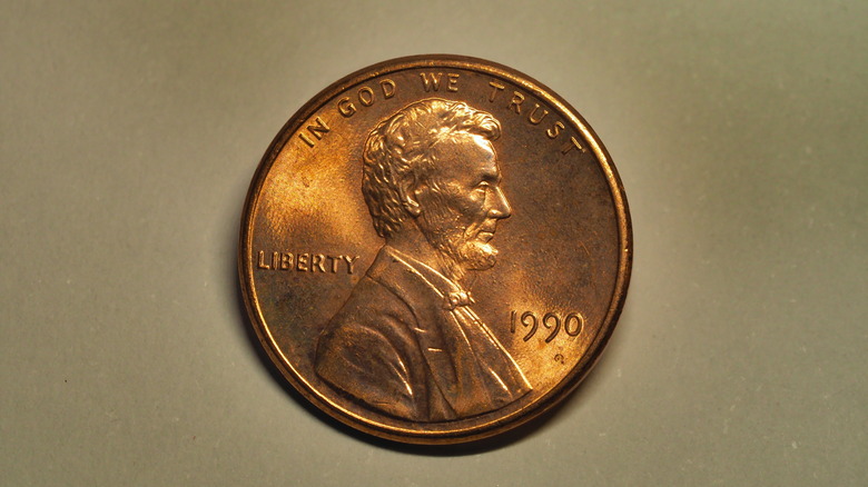 A close-up of a Lincoln penny against a copper backdrop.