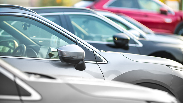 A line of used cars parked outside a dealership