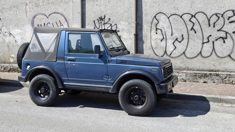Vintage small offroad Suzuki Samurai, or Suzuki Jimny, at the roadside.