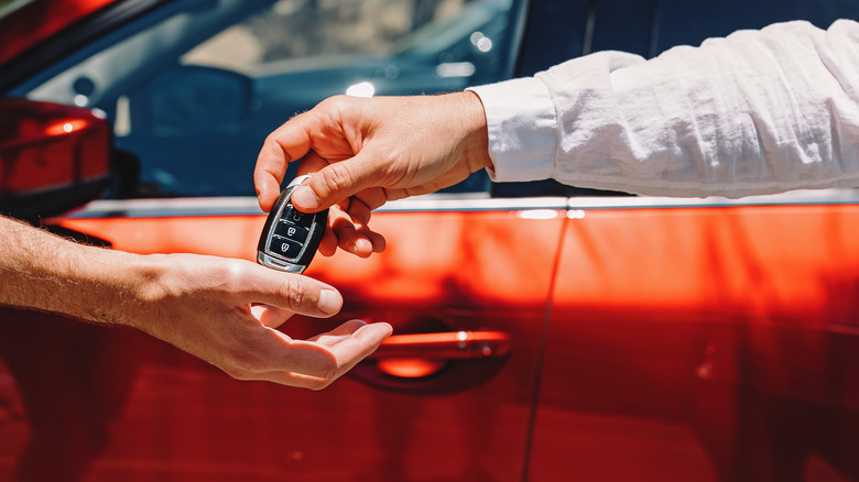 dealer handing car keys to a buyer