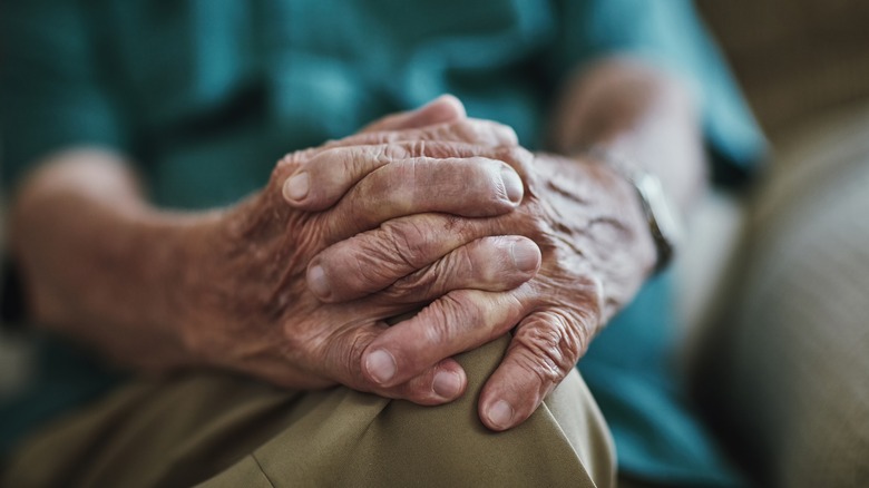 Close up of elderly person clasping their hands together