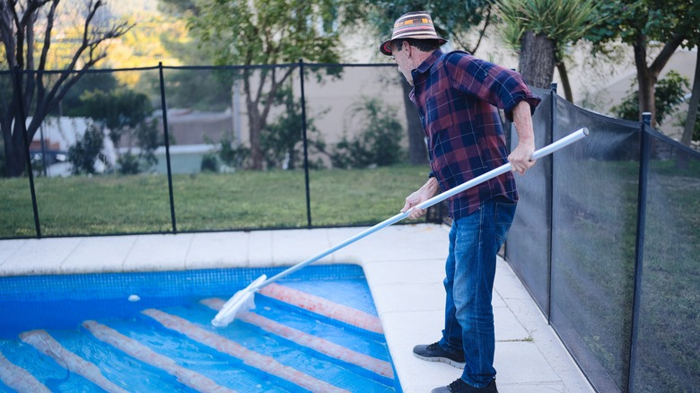 senior cleaning his pool