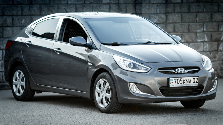 Hyundai accent in grey color, front and right side view.