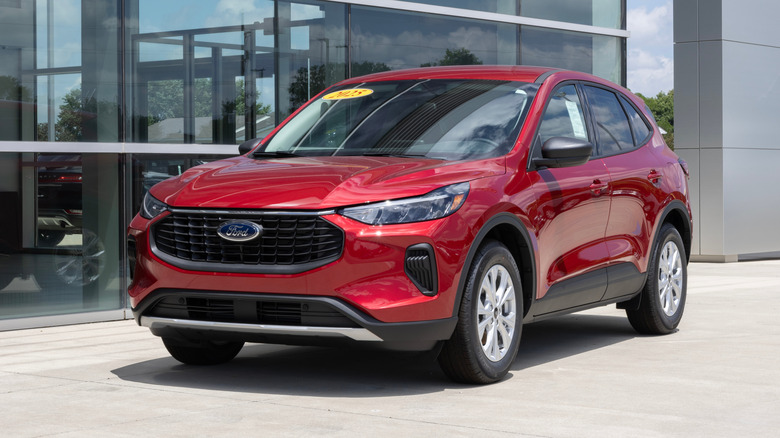A red Ford Hybrid Escape outside dealership.