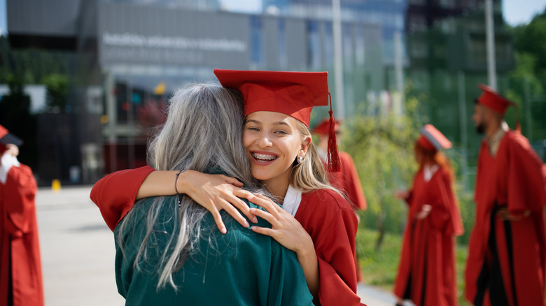 grandmother hugging granddaughter during graduation
