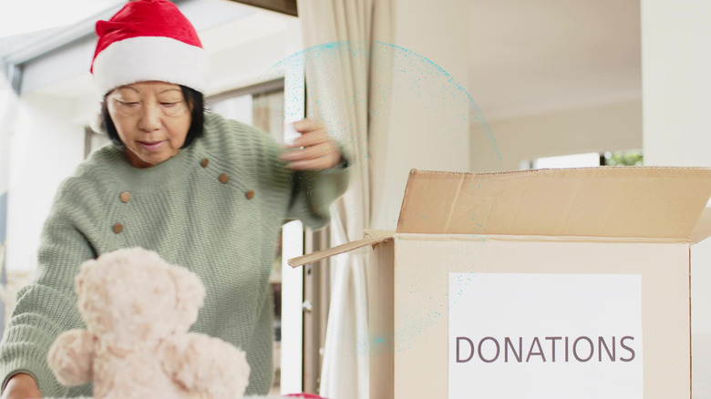 senior putting things in a donation box