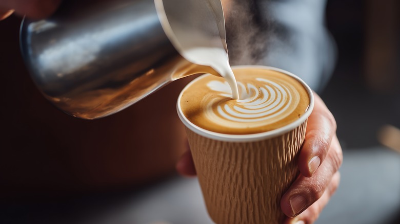 barista pouring a cup of coffee
